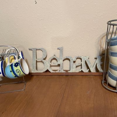 Behave sign and mugs on holders