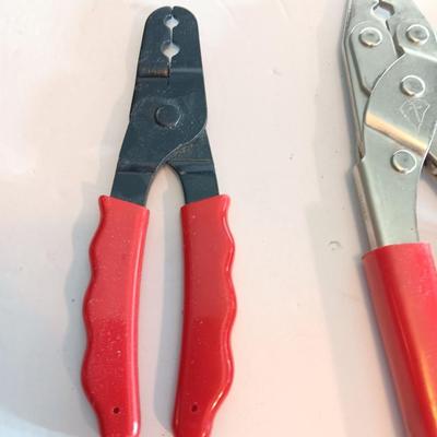 Red handled pliers with a 12' tape measure