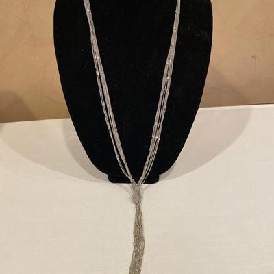 Long silver tone chain with knotted tassel desin