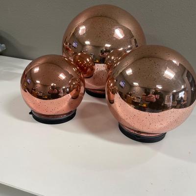 3 Copper colored spheres that light up