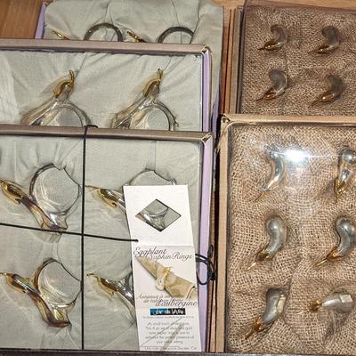 New in package vintage lot of silver plated and gold tone napkin rings and knife rests