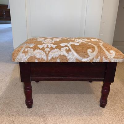 small upholstered footstool with hinged top