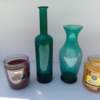 Colored bottle and vase with two scented candles in jars
