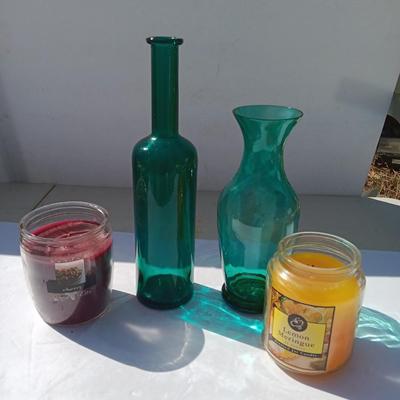 Colored bottle and vase with two scented candles in jars