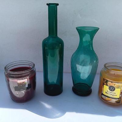 Colored bottle and vase with two scented candles in jars