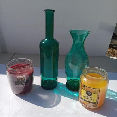Colored bottle and vase with two scented candles in jars