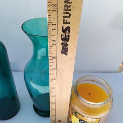 Colored bottle and vase with two scented candles in jars