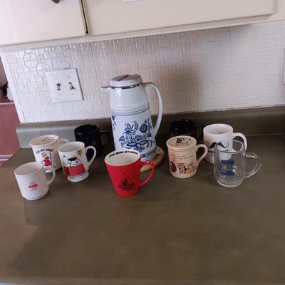 A VARIETY OF COFFEE CUPS AND A CARAFE