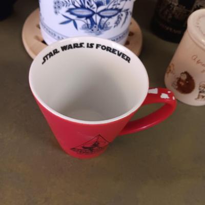 A VARIETY OF COFFEE CUPS AND A CARAFE