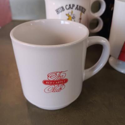 A VARIETY OF COFFEE CUPS AND A CARAFE