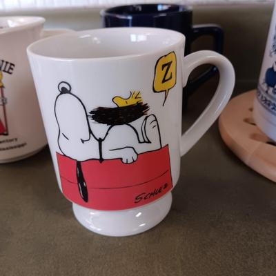 A VARIETY OF COFFEE CUPS AND A CARAFE