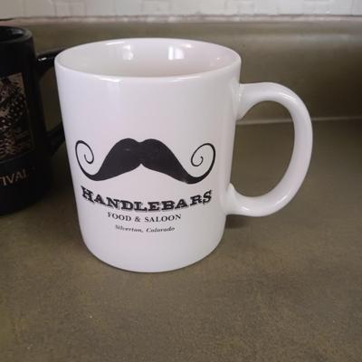 A VARIETY OF COFFEE CUPS AND A CARAFE