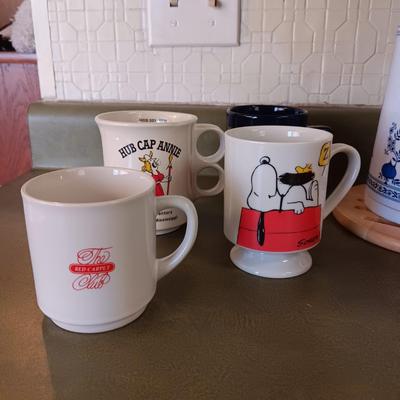 A VARIETY OF COFFEE CUPS AND A CARAFE