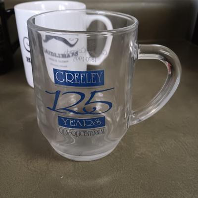 A VARIETY OF COFFEE CUPS AND A CARAFE