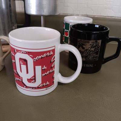 VARIETY OF COFFEE CUPS AND A PERCOLATOR