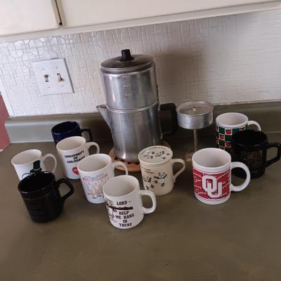 VARIETY OF COFFEE CUPS AND A PERCOLATOR