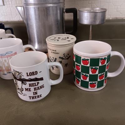 VARIETY OF COFFEE CUPS AND A PERCOLATOR