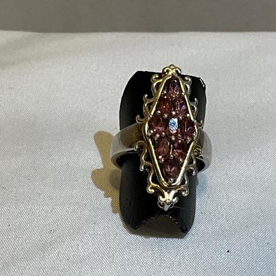 Stamped Ring size 9,, metal two tone, stones are pink in color