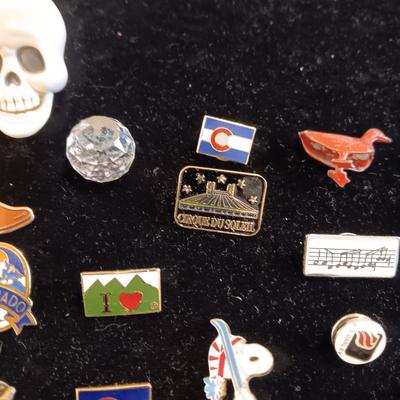 A COLLECTION OF PINS, PATCHES, WOODEN CARD AND WIND UP SKELETON