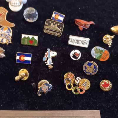 A COLLECTION OF PINS, PATCHES, WOODEN CARD AND WIND UP SKELETON