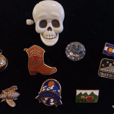A COLLECTION OF PINS, PATCHES, WOODEN CARD AND WIND UP SKELETON