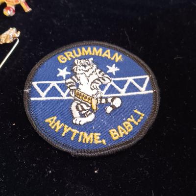 A COLLECTION OF PINS, PATCHES, WOODEN CARD AND WIND UP SKELETON