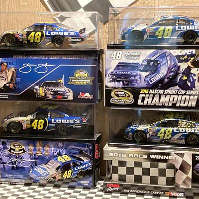 LOT 59: NASCAR - Jimmy Johnson #48 Lowe's Motor Speedway Flag and Four Die-Cast 1:24 Scale Race Cars