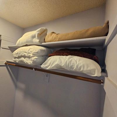 Assorted bed blankets and pillows