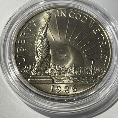 1986-D UNCIRCULATED STATUE OF LIBERTY HALF DOLLAR IN A MINT HOLDER AS PICTURED.