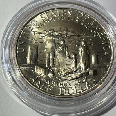 1986-D UNCIRCULATED STATUE OF LIBERTY HALF DOLLAR IN A MINT HOLDER AS PICTURED.