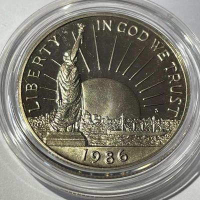 1986-S PROOF STATUE OF LIBERTY HALF DOLLAR IN A MINT HOLDER AS PICTURED.