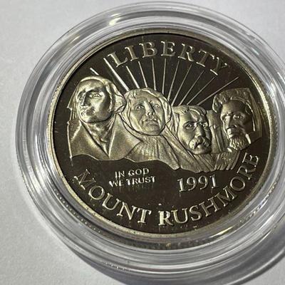 1991-S PROOF MOUNT RUSHMORE HALF DOLLAR IN A MINT HOLDER AS PICTURED.