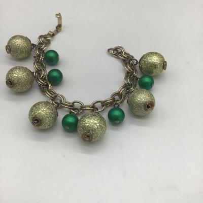 Green dangle charms on charm bracelet