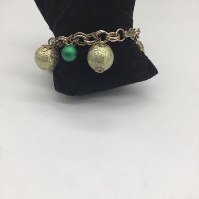 Green dangle charms on charm bracelet