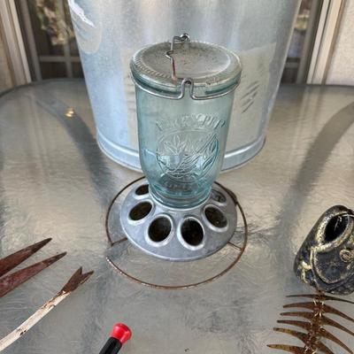 BIRD FEEDER WITH BIRD FOOD IN METAL CAN, METAL FISH WINDCHIME, AND GARDEN TOOLS