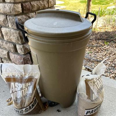 RUBBERMAID TRASH CAN AND 3 BAGS OF PAVER SAND