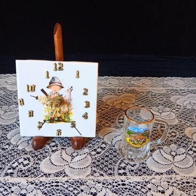 SMALL BATTERY OPERATED CLOCK ON STAND AND A GERMAN SHOT GLASS