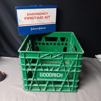 HEAVY PLASTIC MILK CRATE AND A METAL FIRST-AID KIT WITH SOME CONTENTS