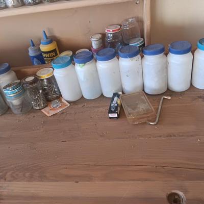 PLASTIC BOTTLES OF HARDWARE AND A HOMEMADE ANVIL