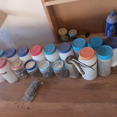 PLASTIC BOTTLES OF HARDWARE AND A HOMEMADE ANVIL