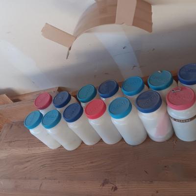 PLASTIC BOTTLES OF HARDWARE AND A HOMEMADE ANVIL