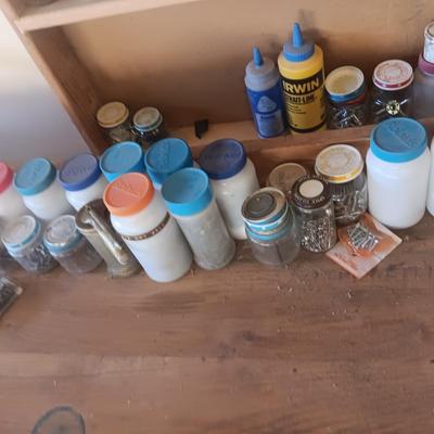 PLASTIC BOTTLES OF HARDWARE AND A HOMEMADE ANVIL