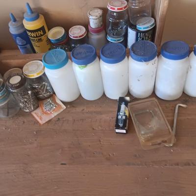 PLASTIC BOTTLES OF HARDWARE AND A HOMEMADE ANVIL