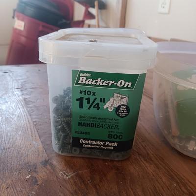 PLASTIC BOTTLES OF HARDWARE AND A HOMEMADE ANVIL