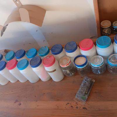 PLASTIC BOTTLES OF HARDWARE AND A HOMEMADE ANVIL