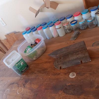 PLASTIC BOTTLES OF HARDWARE AND A HOMEMADE ANVIL