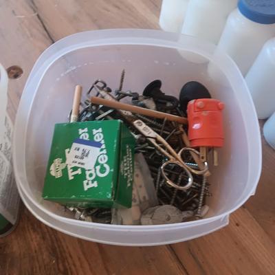 PLASTIC BOTTLES OF HARDWARE AND A HOMEMADE ANVIL