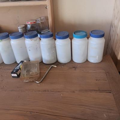 PLASTIC BOTTLES OF HARDWARE AND A HOMEMADE ANVIL