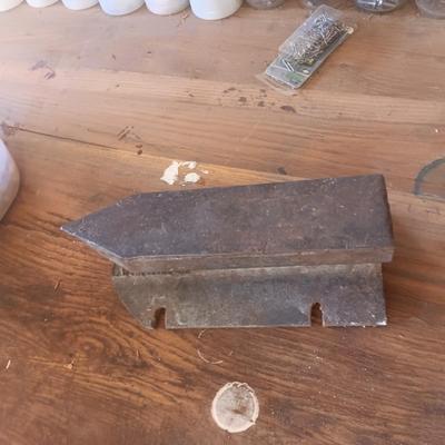 PLASTIC BOTTLES OF HARDWARE AND A HOMEMADE ANVIL