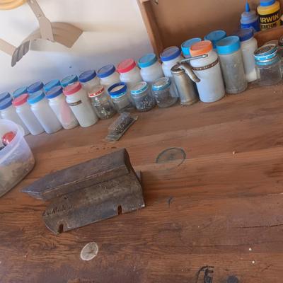 PLASTIC BOTTLES OF HARDWARE AND A HOMEMADE ANVIL